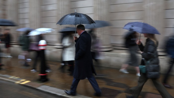 Commuters walk during the morning rush hour near the Bank of England in the City of London